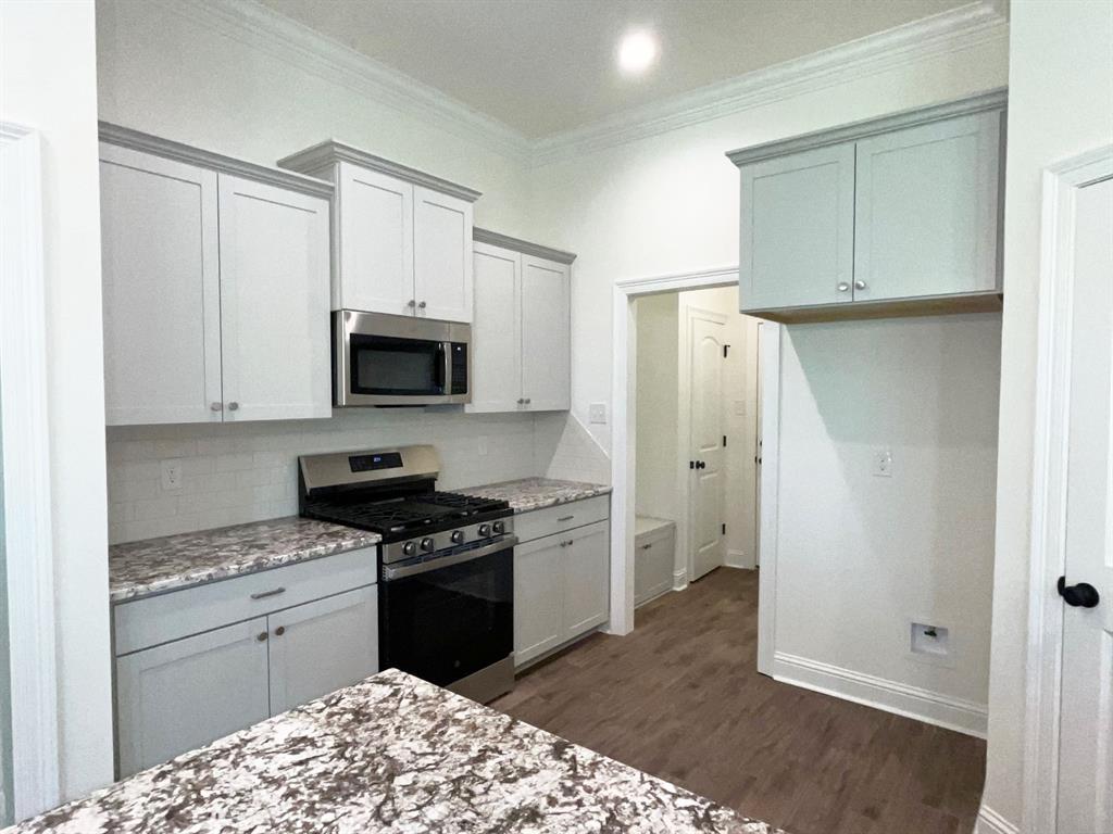 159 Lessie Drive Stonewall, LA 71078 - Photo 9 of 26 a kitchen with a refrigerator stove and white cabinets