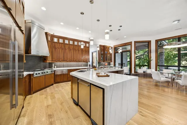 a large kitchen with kitchen island a sink stainless steel appliances and cabinets