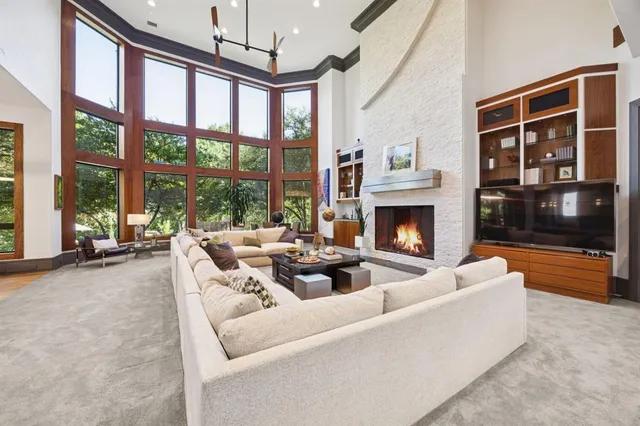 a living room with furniture fireplace and a large window