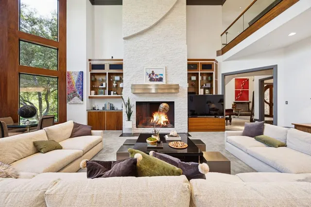 a living room with furniture fireplace and a large window