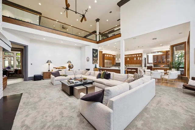 a living room with furniture kitchen view and a chandelier