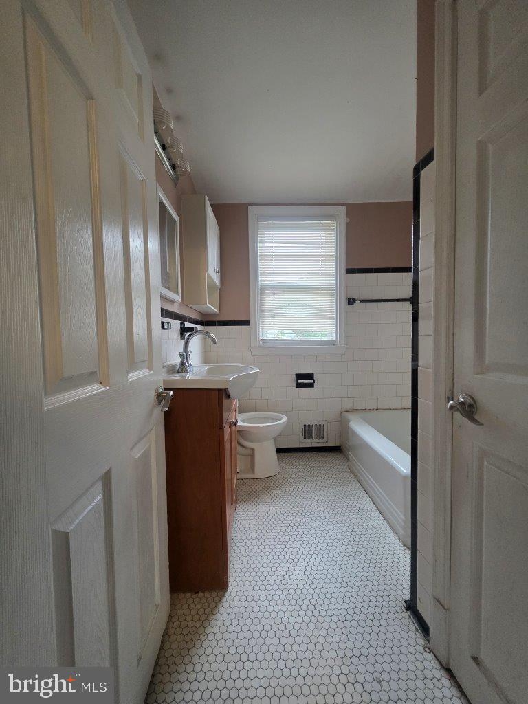 2211 Echodale Avenue Baltimore, MD 21214 - Photo 17 of 30 a kitchen with a refrigerator and window