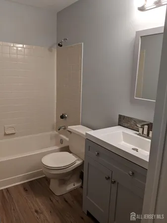 a bathroom with a granite countertop toilet a sink and a mirror