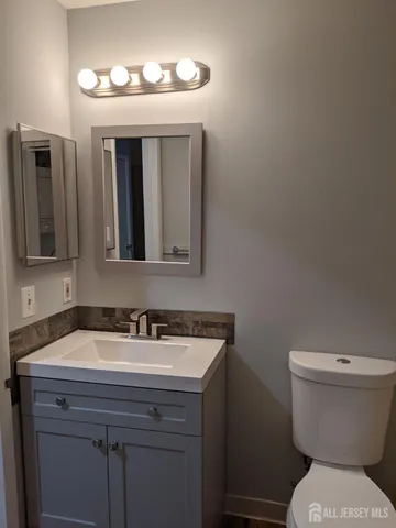 a bathroom with a toilet sink and mirror