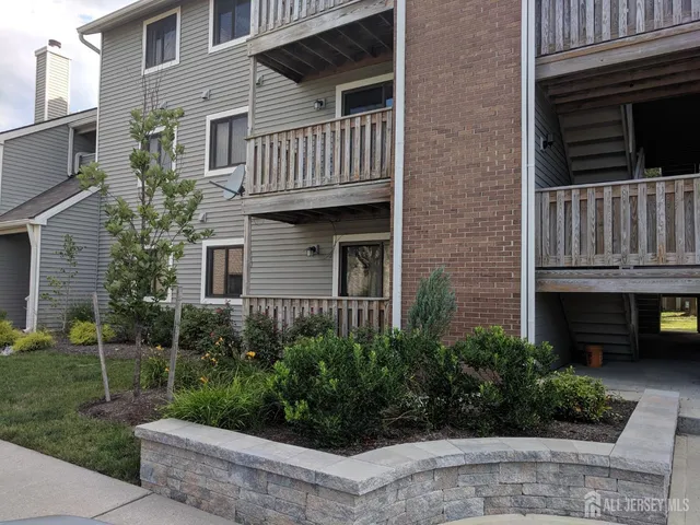 a view of a house with brick walls and a yard with potted plants