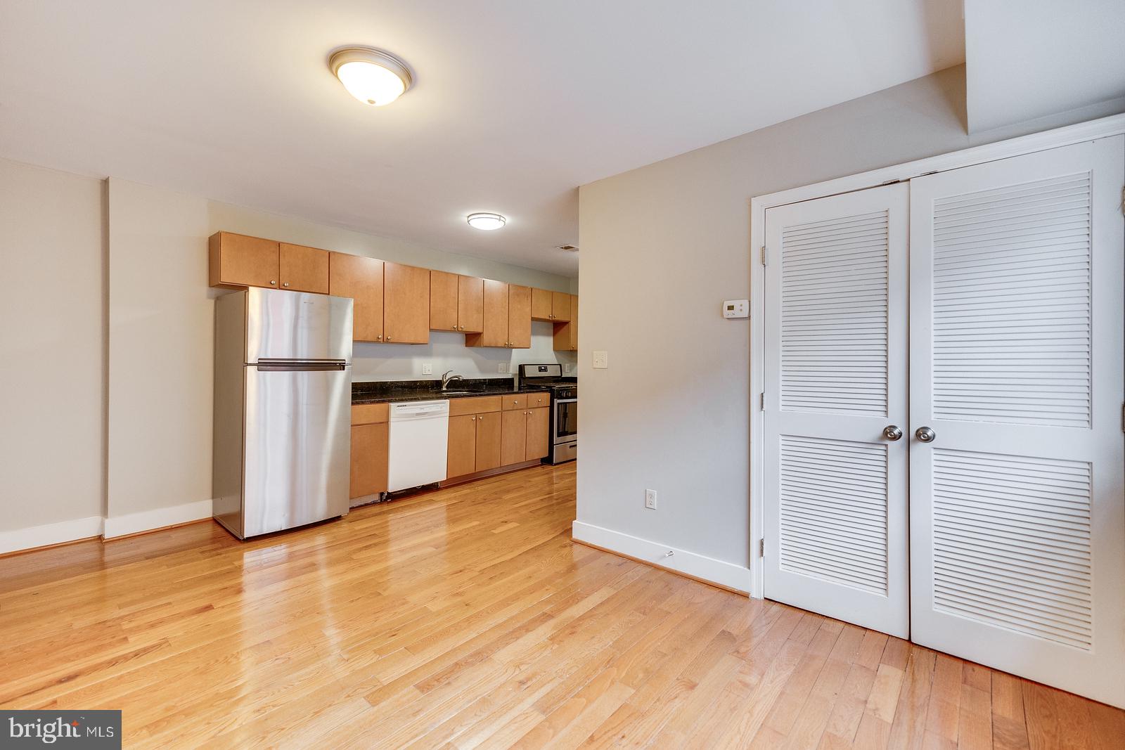 61 Forrester Street Southwest, Unit 104 Washington, DC 20032 - Photo 12 of 13 a kitchen with stainless steel appliances wooden floor and large cabinets
