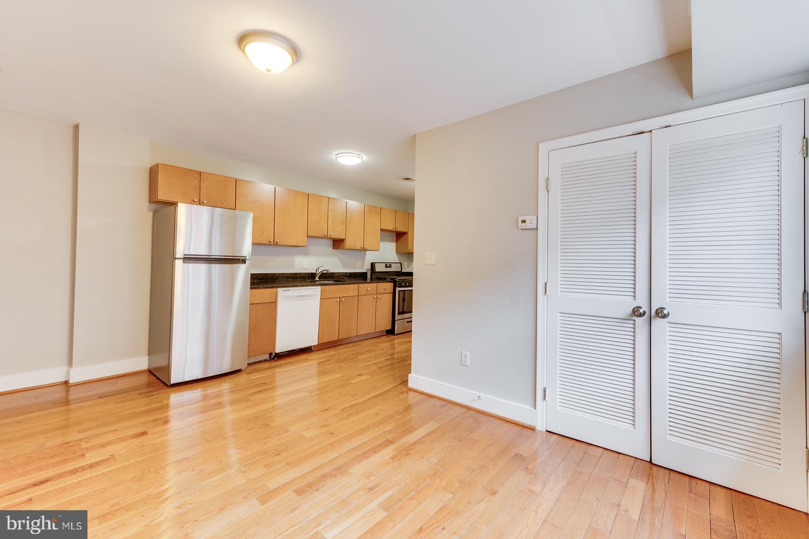 61 Forrester Street Southwest, Unit 104 Washington, DC 20032 - Photo 5 of 13 a kitchen with stainless steel appliances wooden floor and large cabinets