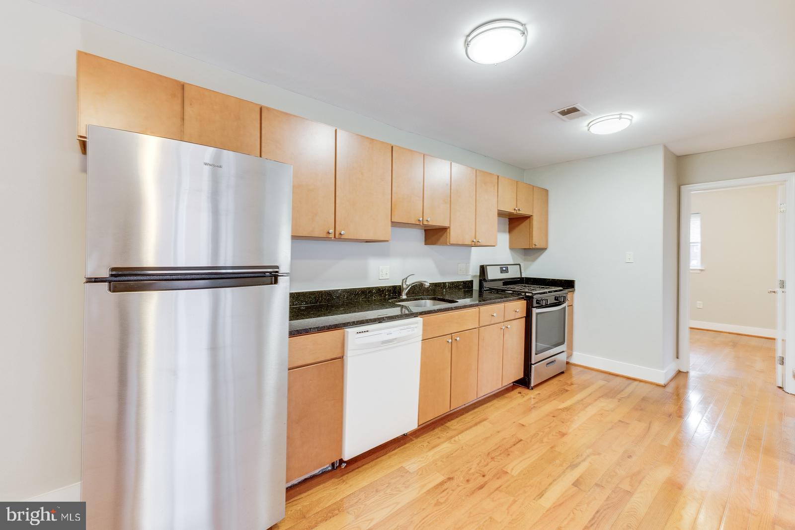 61 Forrester Street Southwest, Unit 104 Washington, DC 20032 - Photo 6 of 13 a kitchen with granite countertop a refrigerator and a sink