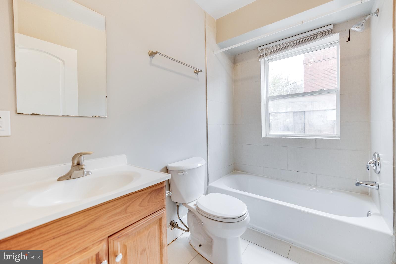 61 Forrester Street Southwest, Unit 104 Washington, DC 20032 - Photo 9 of 13 a bathroom with a sink a toilet and a bathtub