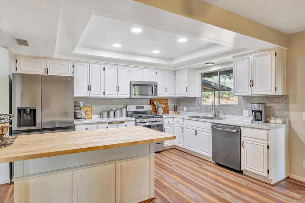 17620 Lyons Valley Road Jamul, CA 91935 - Photo 9 of 32 a kitchen with stainless steel appliances granite countertop a refrigerator sink stove microwave and cabinets