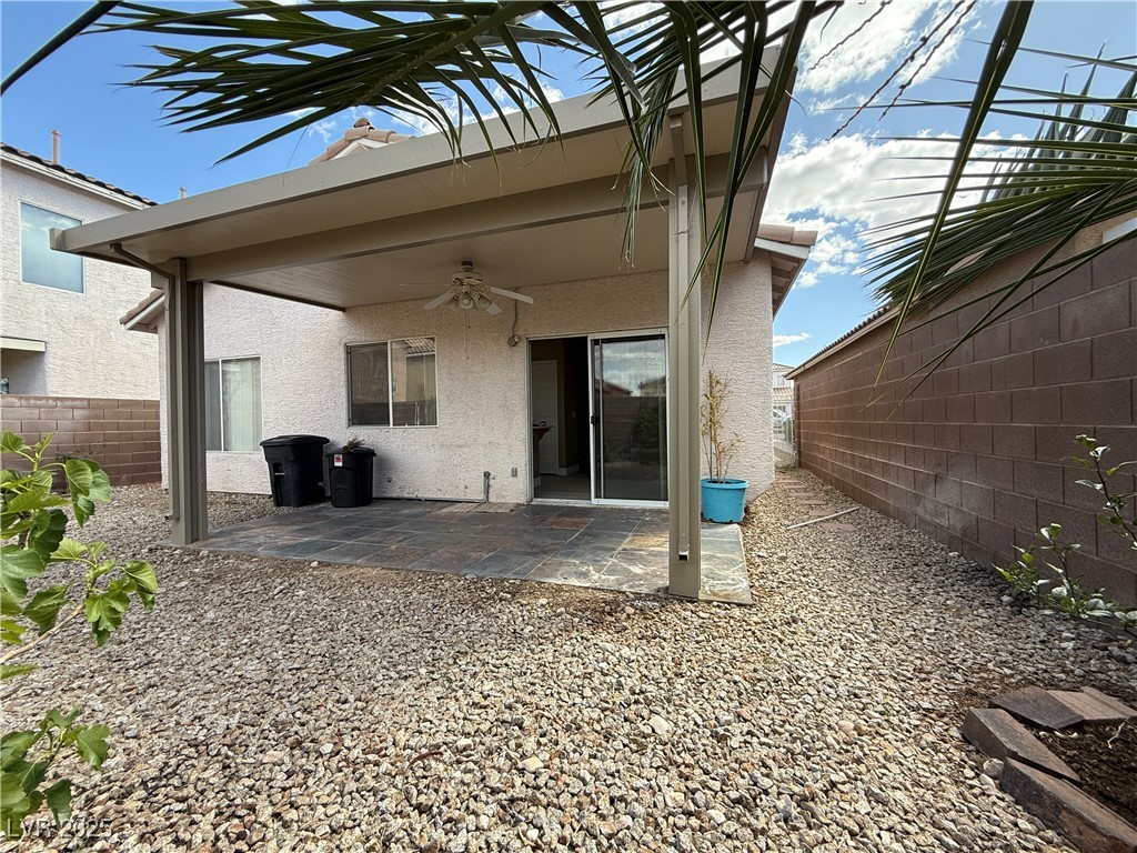 7062 Russell Ranch Avenue Las Vegas, NV 89113 - Photo 16 of 32 Back of property with a patio, stucco siding, fence, and ceiling fan