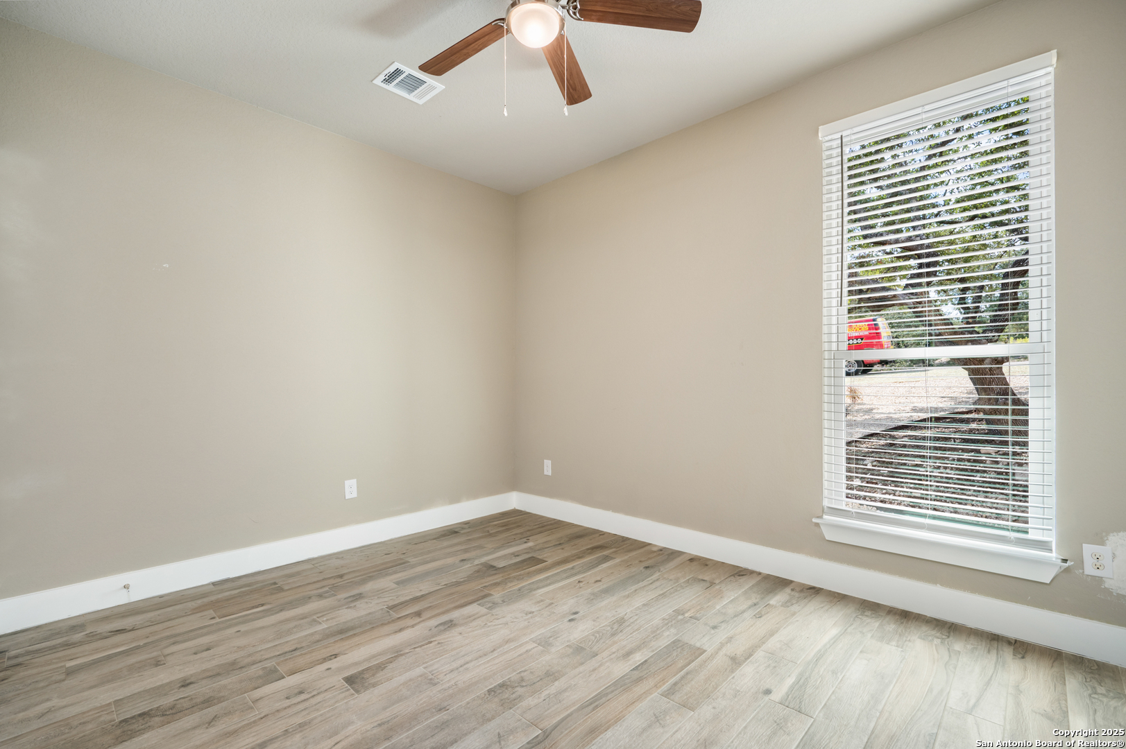 1066 Primrose Path Spring Branch, TX 78070 - Photo 16 of 24 a view of an empty room with wooden floor and a window
