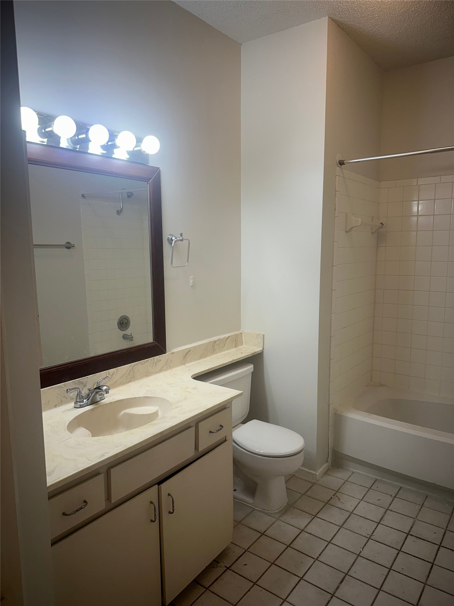 106 East 30th Street, Unit 101 Austin, TX 78705 - Photo 11 of 11 Full bathroom featuring vanity, shower / washtub combination, a textured ceiling, and light tile patterned flooring