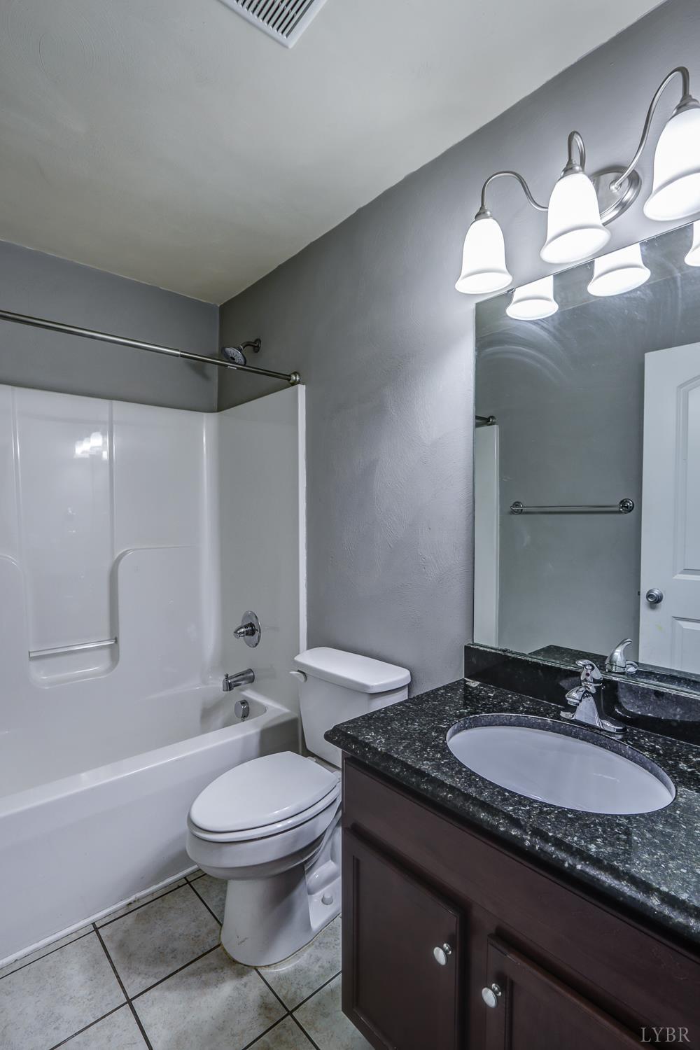 1057 Old Trail Road Forest, VA 24551 - Photo 36 of 49 a bathroom with a granite countertop sink vanity mirror bathtub shower and a toilet