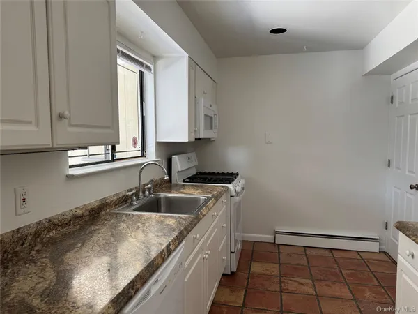 a kitchen with a sink cabinets and window