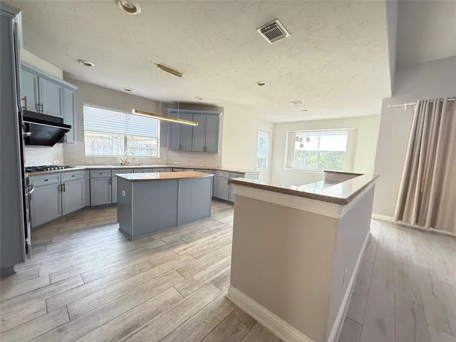 a kitchen with granite countertop a sink stove and cabinets