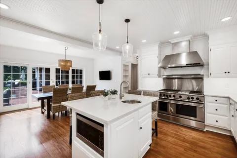 a kitchen with a stove and a wooden floor