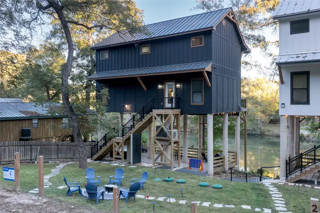 a view of an house with backyard space and a tree