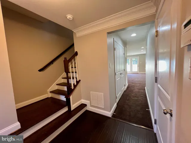 a view of a hallway with wooden floor and stairs