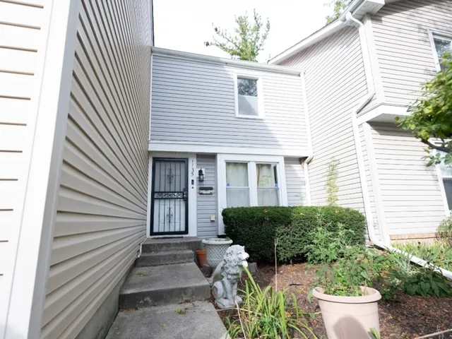 a view of a house with chairs and a yard