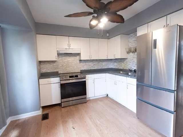 a kitchen with a refrigerator and a stove top oven