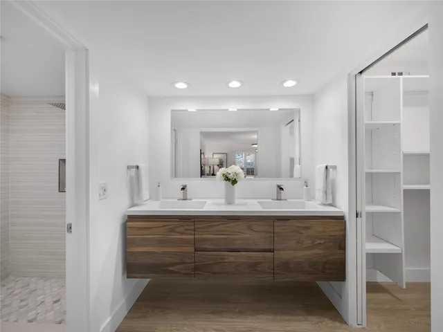 a bathroom with a sink mirror and a shower