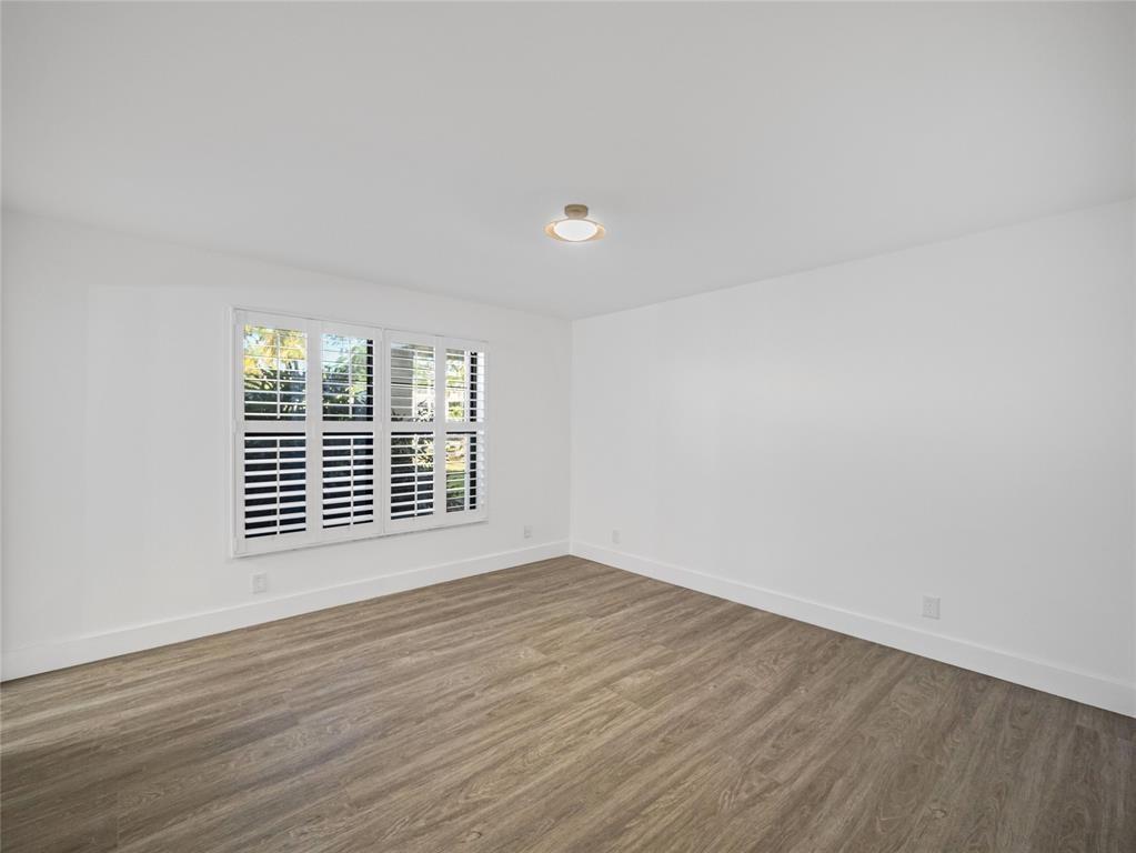 300 North Hwy A1A, Unit 103E Jupiter, FL 33477 - Photo 7 of 12 a view of an empty room with wooden floor and a window