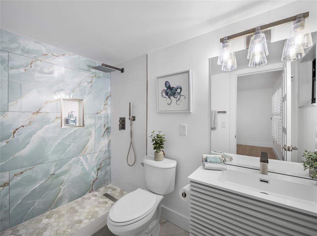 300 North Hwy A1A, Unit 103E Jupiter, FL 33477 - Photo 8 of 12 a bathroom with a sink a toilet a mirror and shower