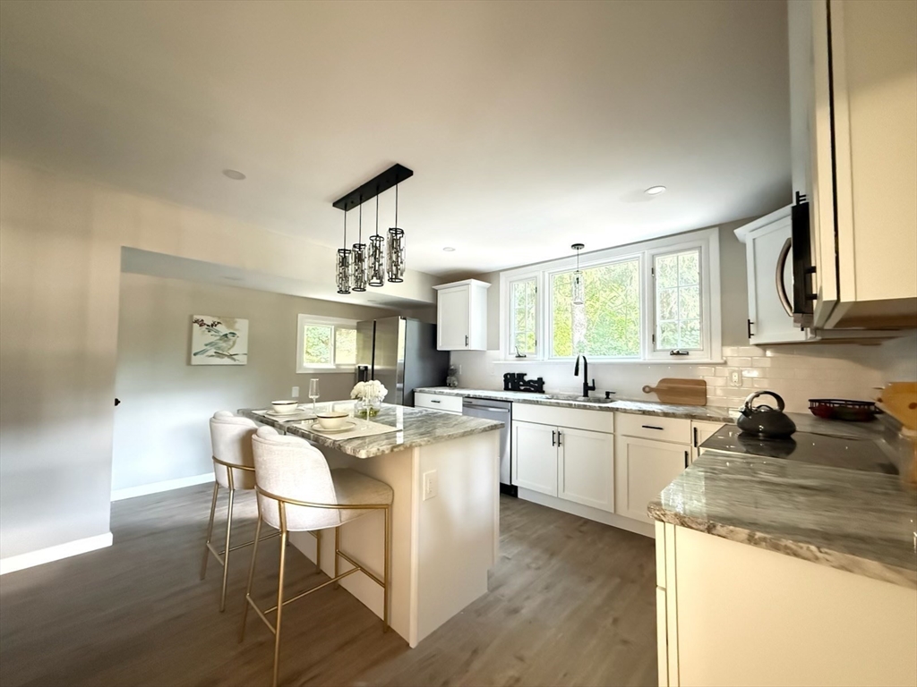 37 Bridge Street Monson, MA 01057 - Photo 2 of 35 a kitchen with a stove a sink a dining table and chairs