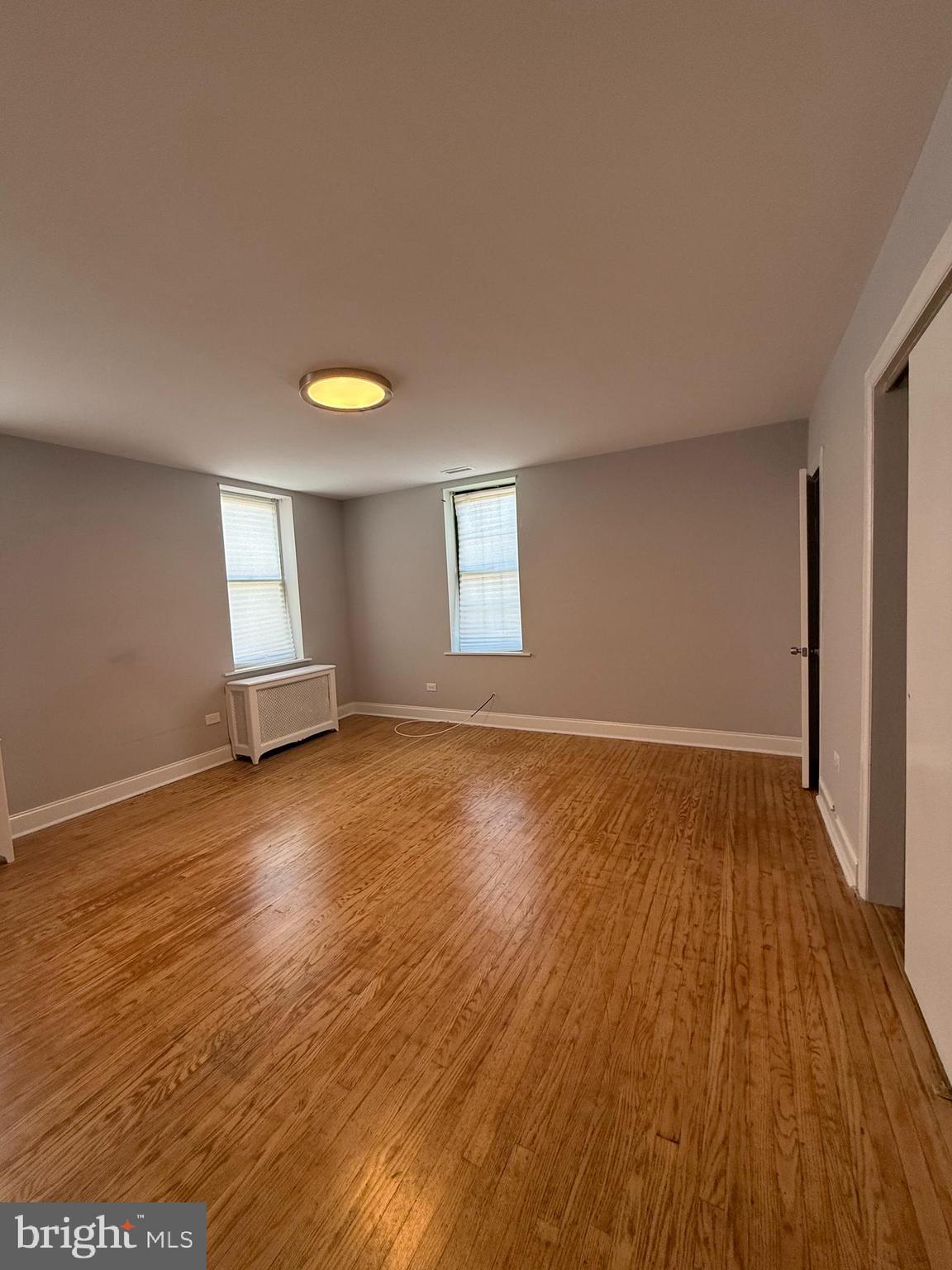 1208 Mifflin Street, Unit 2 Philadelphia, PA 19148 - Photo 12 of 14 an empty room with wooden floor and windows