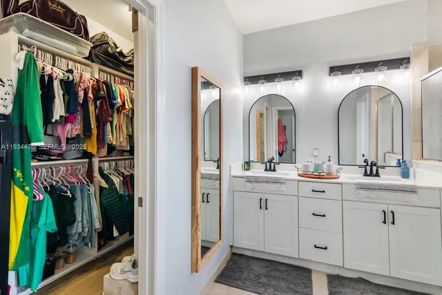 a spacious bathroom with a double vanity sink a toilet and a shower