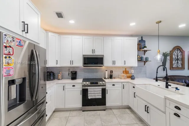 a kitchen with white cabinets and appliances