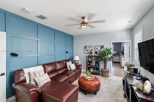 a living room with furniture a flat screen tv and a potted plant