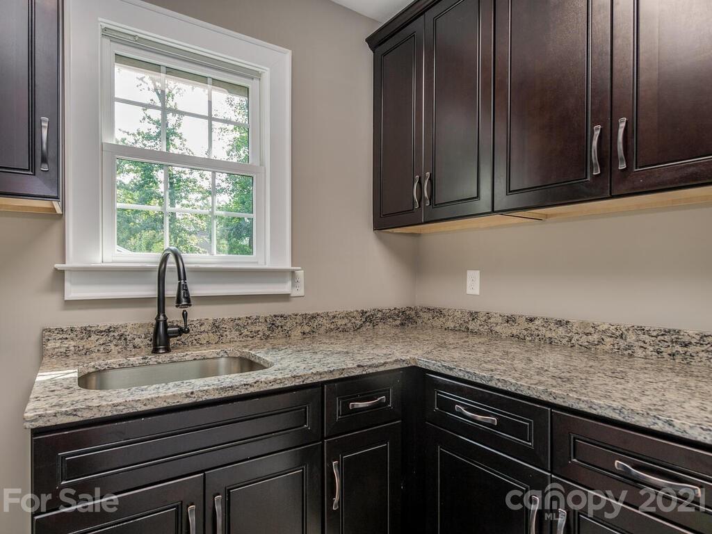5923 Sharon View Road Charlotte, NC 28226 - Photo 11 of 44 a kitchen with granite countertop a sink a stove and cabinets
