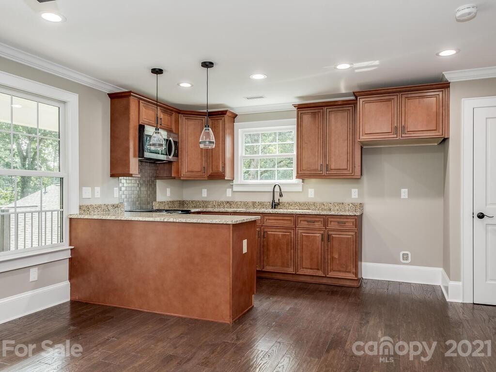 5923 Sharon View Road Charlotte, NC 28226 - Photo 28 of 44 a kitchen with granite countertop a stove a sink and a refrigerator