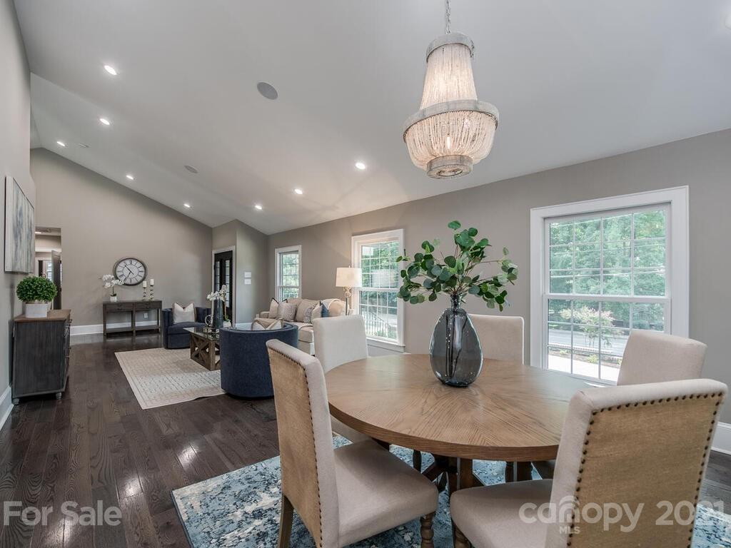 5923 Sharon View Road Charlotte, NC 28226 - Photo 3 of 44 a dining room with wooden floor a chandelier a wooden table and chairs