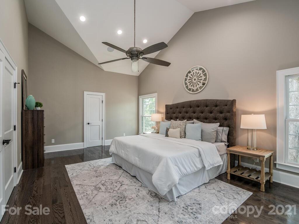 5923 Sharon View Road Charlotte, NC 28226 - Photo 6 of 44 a bedroom with a large bed and a chandelier