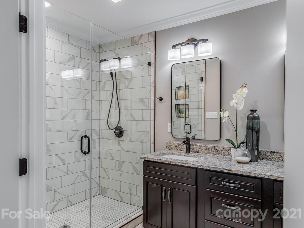 5923 Sharon View Road Charlotte, NC 28226 - Photo 8 of 44 a bathroom with a granite countertop sink a mirror and shower
