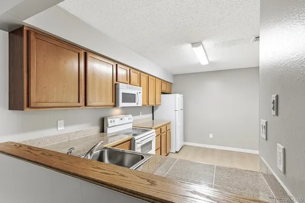 a kitchen with granite countertop a sink and a stove top oven