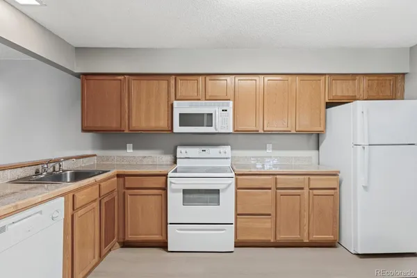 a kitchen with white cabinets and white appliances