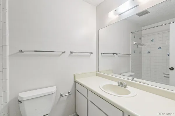 a bathroom with a granite countertop sink toilet and shower