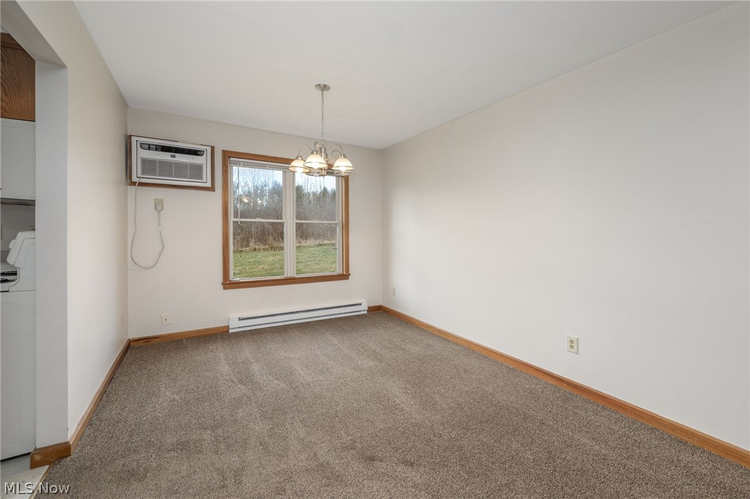 8464-8446 Tallmadge Road Diamond, OH 44412 - Photo 8 of 39 Empty room featuring a chandelier, light carpet, and a baseboard radiator