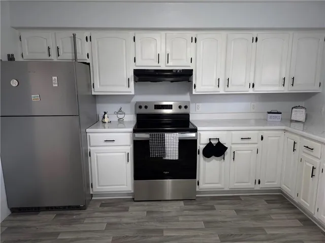 a kitchen with a white stove top oven and refrigerator