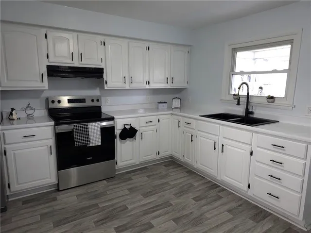 a kitchen with granite countertop white cabinets and white appliances