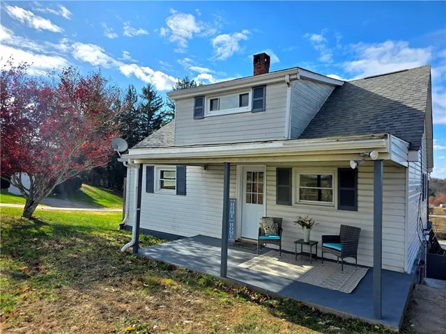 a view of a house with backyard and sitting area