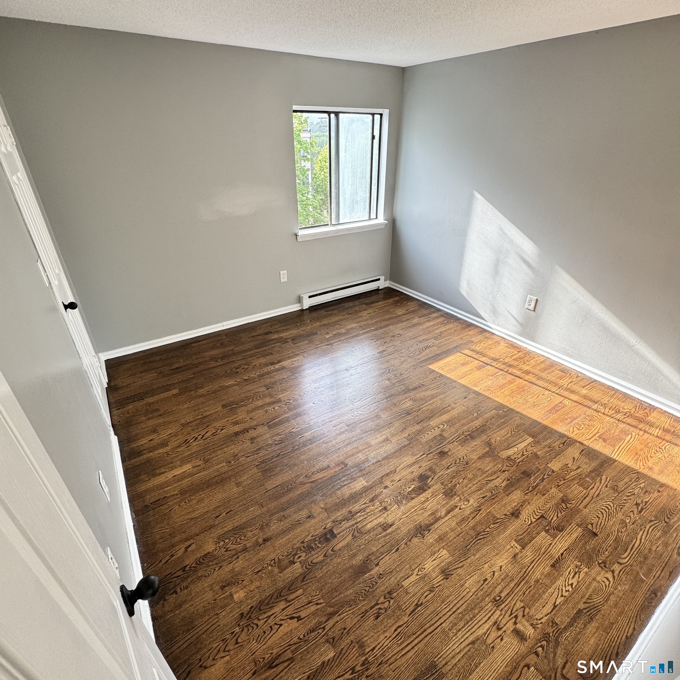 32 Old Foxon Road, Unit 42 East Haven, CT 06513 - Photo 3 of 4 an empty room with wooden floor and windows