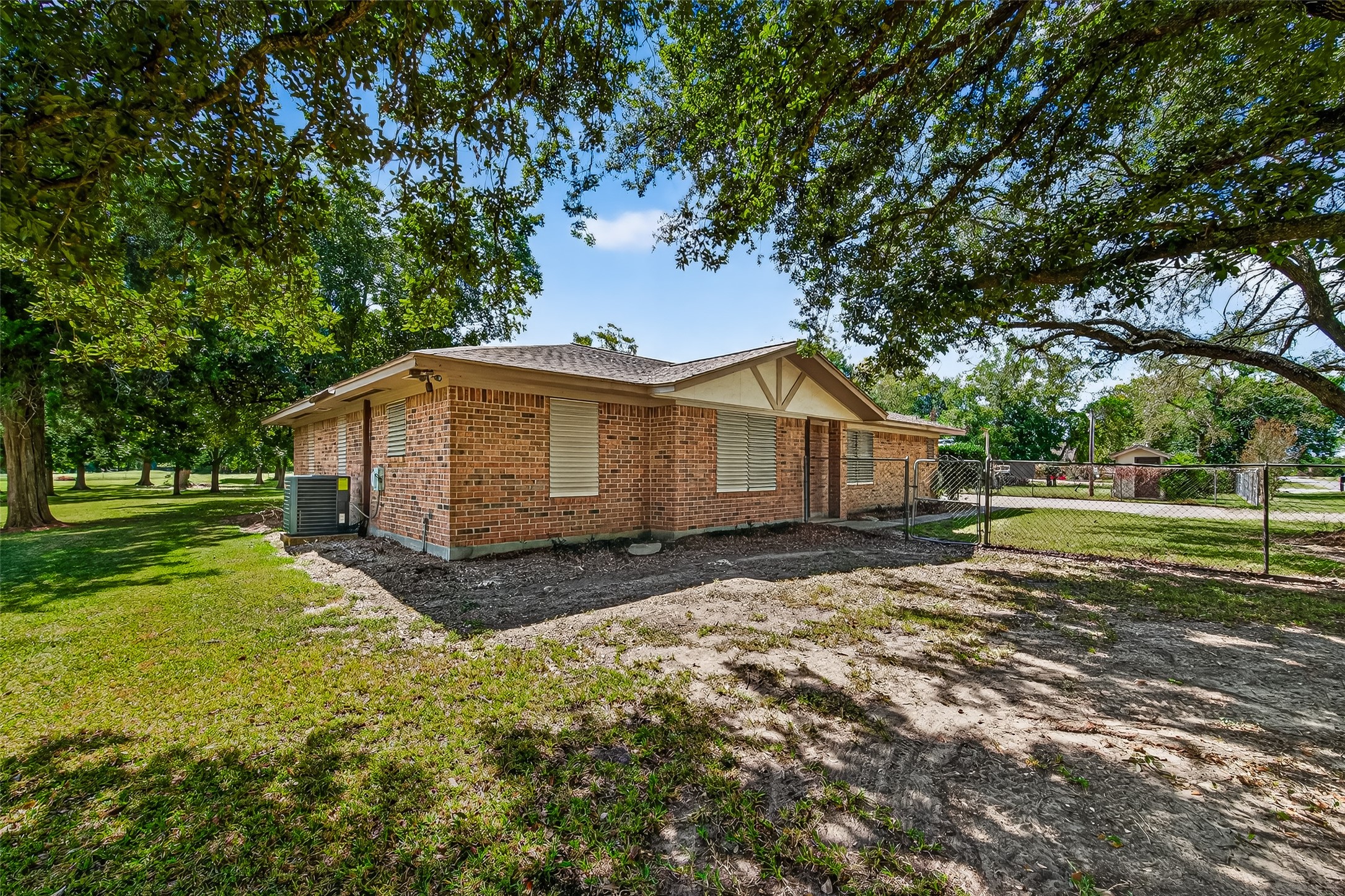12021 7th 1/2 Street Santa Fe, TX 77510 - Photo 4 of 49 Charming brick home with a spacious, fenced yard and mature trees providing ample shade. Ideal for privacy and outdoor enjoyment.