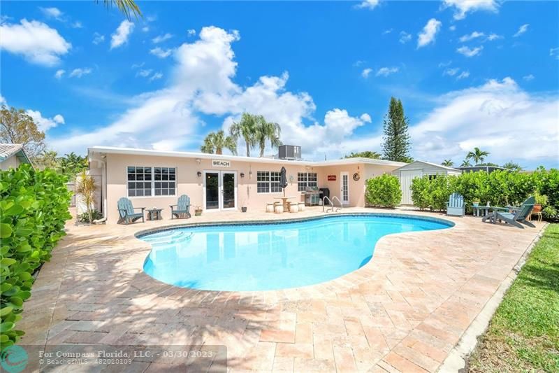 a view of house with swimming pool and yard