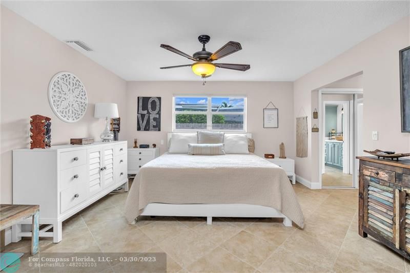 5206 Cleveland Street Hollywood, FL 33021 - Photo 15 of 49 a bedroom with a bed and a chandelier