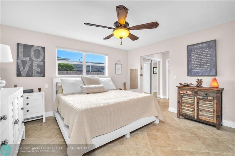 5206 Cleveland Street Hollywood, FL 33021 - Photo 16 of 49 a bedroom with a bed and a chandelier